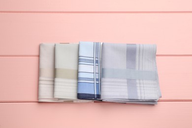 Different handkerchiefs folded on pink wooden table, flat lay Photo of Different handkerchiefs folded on pink wooden table, flat lay