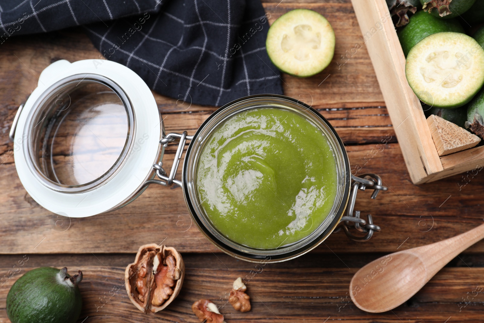 Feijoa jam in glass jar on wooden table, flat lay Photo of Feijoa jam in glass jar on wooden table, flat lay