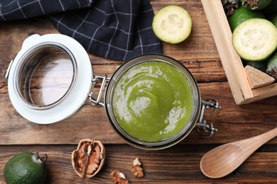 Feijoa jam in glass jar on wooden table, flat lay Photo of Feijoa jam in glass jar on wooden table, flat lay