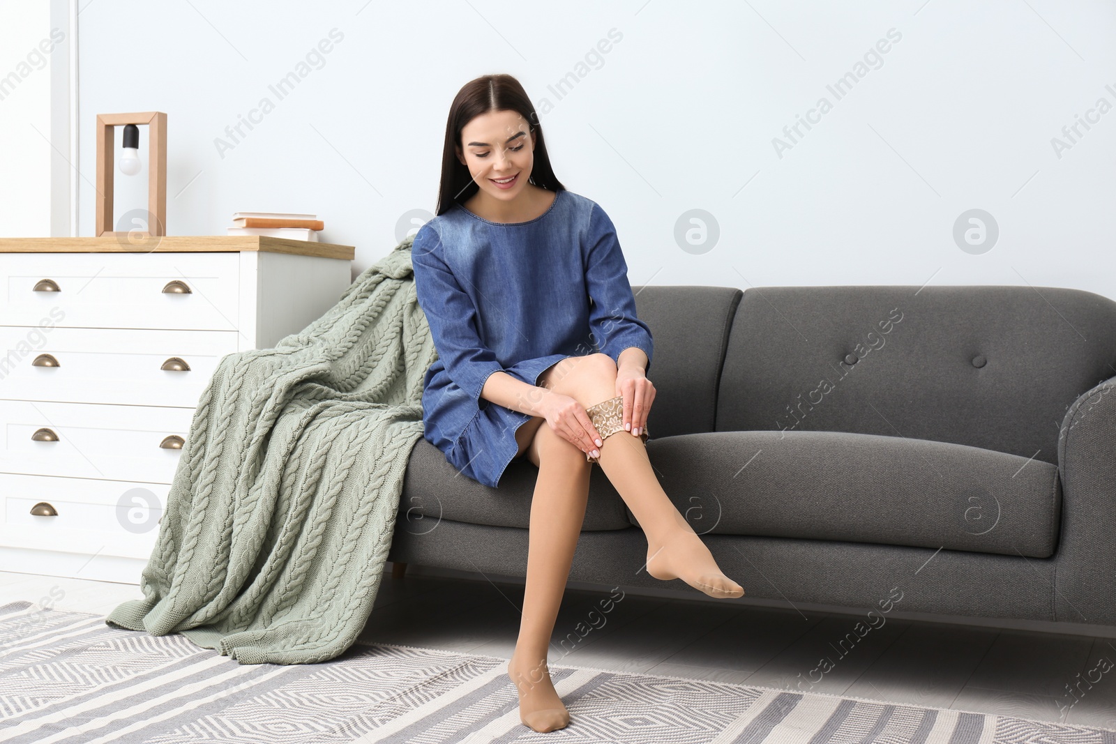 Woman wearing compression tights in living room. Space for text Photo of Woman wearing compression tights in living room. Space for text