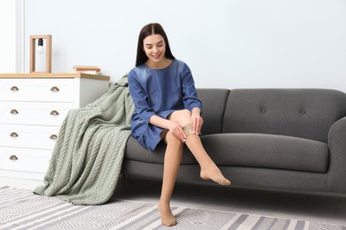 Photo of Woman wearing compression tights in living room. Space for text