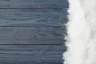 Artificial snow on blue wooden background, top view with space for text. Christmas decor Photo of Artificial snow on blue wooden background, top view with space for text. Christmas decor