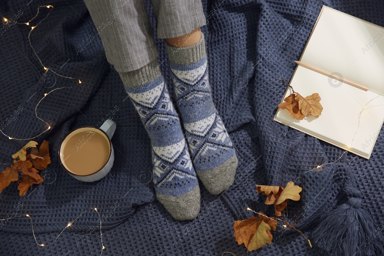 Woman wearing knitted socks on warm plaid, top view. Cozy season Photo of Woman wearing knitted socks on warm plaid, top view. Cozy season
