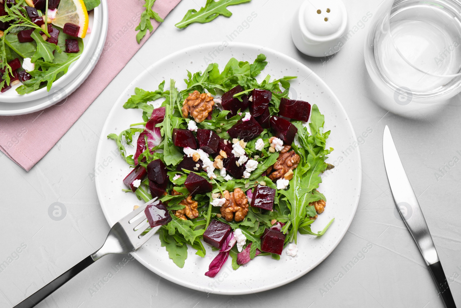 Delicious beet salad served on grey table, flat lay Photo of Delicious beet salad served on grey table, flat lay