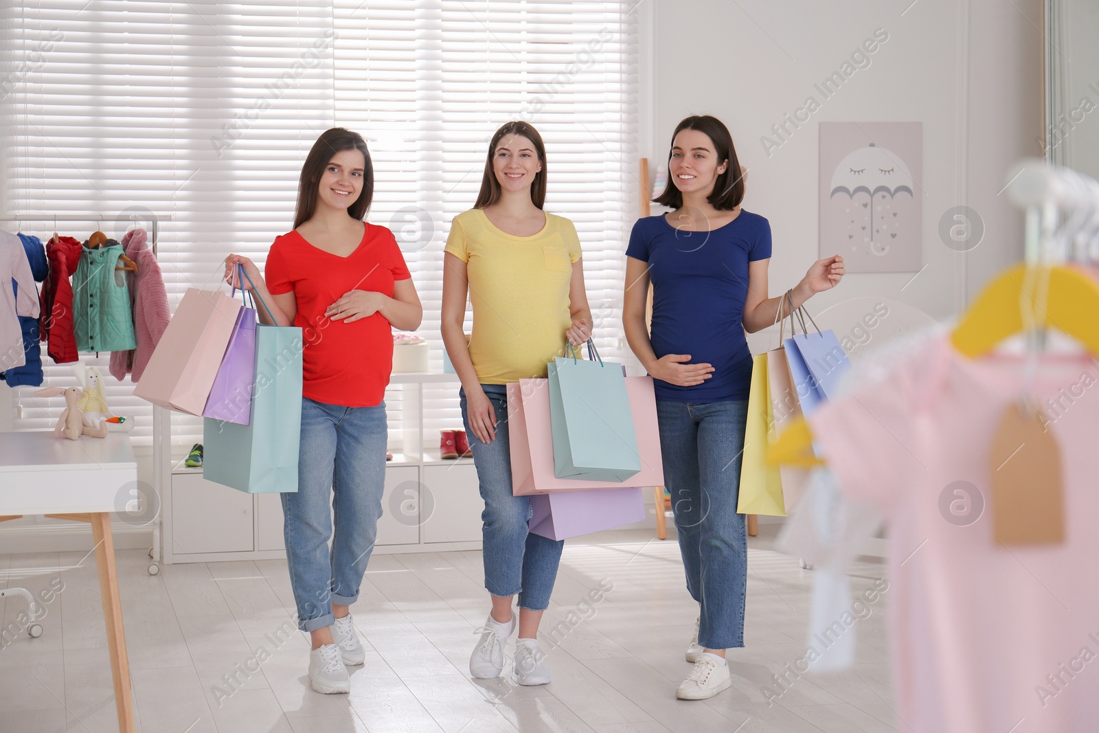 Happy pregnant women with shopping bags in store Photo of Happy pregnant women with shopping bags in store