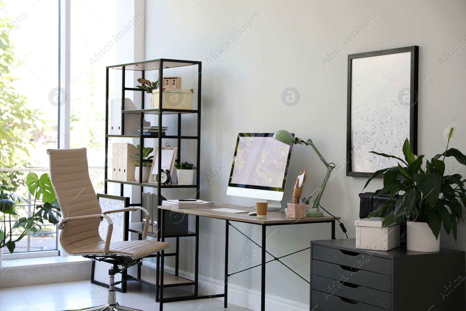 Comfortable office chair near desk with modern computer indoors Photo of Comfortable office chair near desk with modern computer indoors