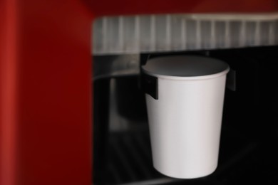 Paper cup with coffee in vending machine, closeup Photo of Paper cup with coffee in vending machine, closeup