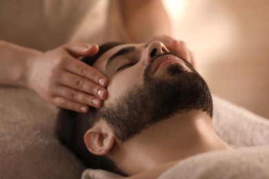 Young man receiving facial massage in beauty salon, closeup Photo of Young man receiving facial massage in beauty salon, closeup