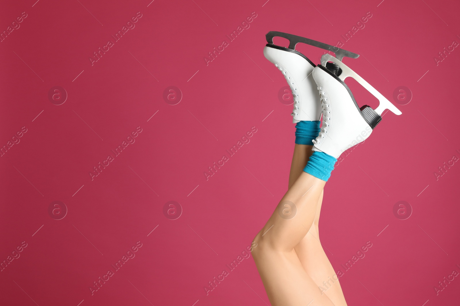Woman in elegant white ice skates on pink background, closeup of legs. Space for text Photo of Woman in elegant white ice skates on pink background, closeup of legs. Space for text