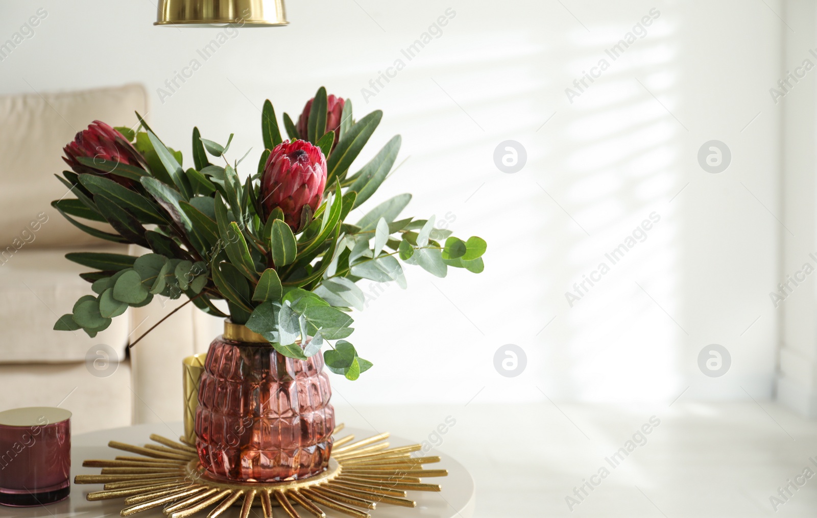 Vase with bouquet of beautiful Protea flowers on table in room Photo of Vase with bouquet of beautiful Protea flowers on table in room