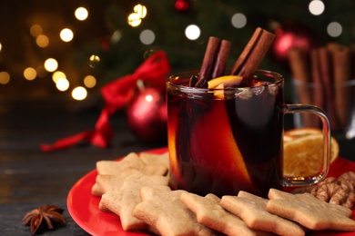 Aromatic mulled wine and cookies on wooden table, closeup Photo of Aromatic mulled wine and cookies on wooden table, closeup