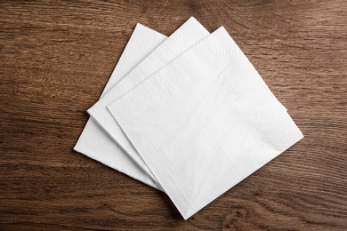 White clean paper tissues on wooden table, top view Photo of White clean paper tissues on wooden table, top view