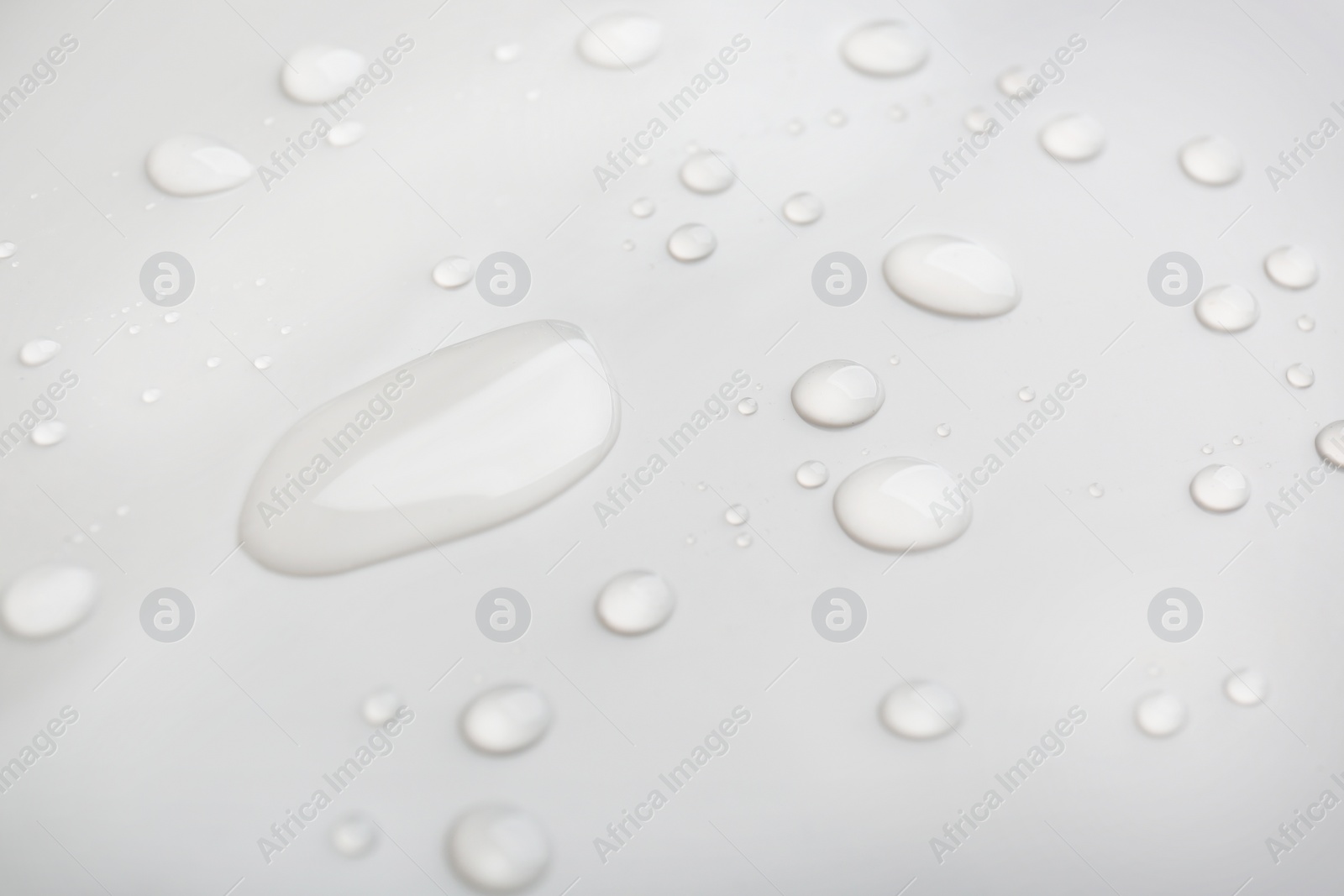 Drops of spilled water on grey background, closeup Photo of Drops of spilled water on grey background, closeup