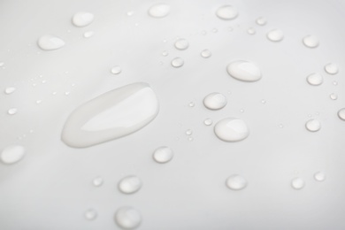 Drops of spilled water on grey background, closeup Photo of Drops of spilled water on grey background, closeup