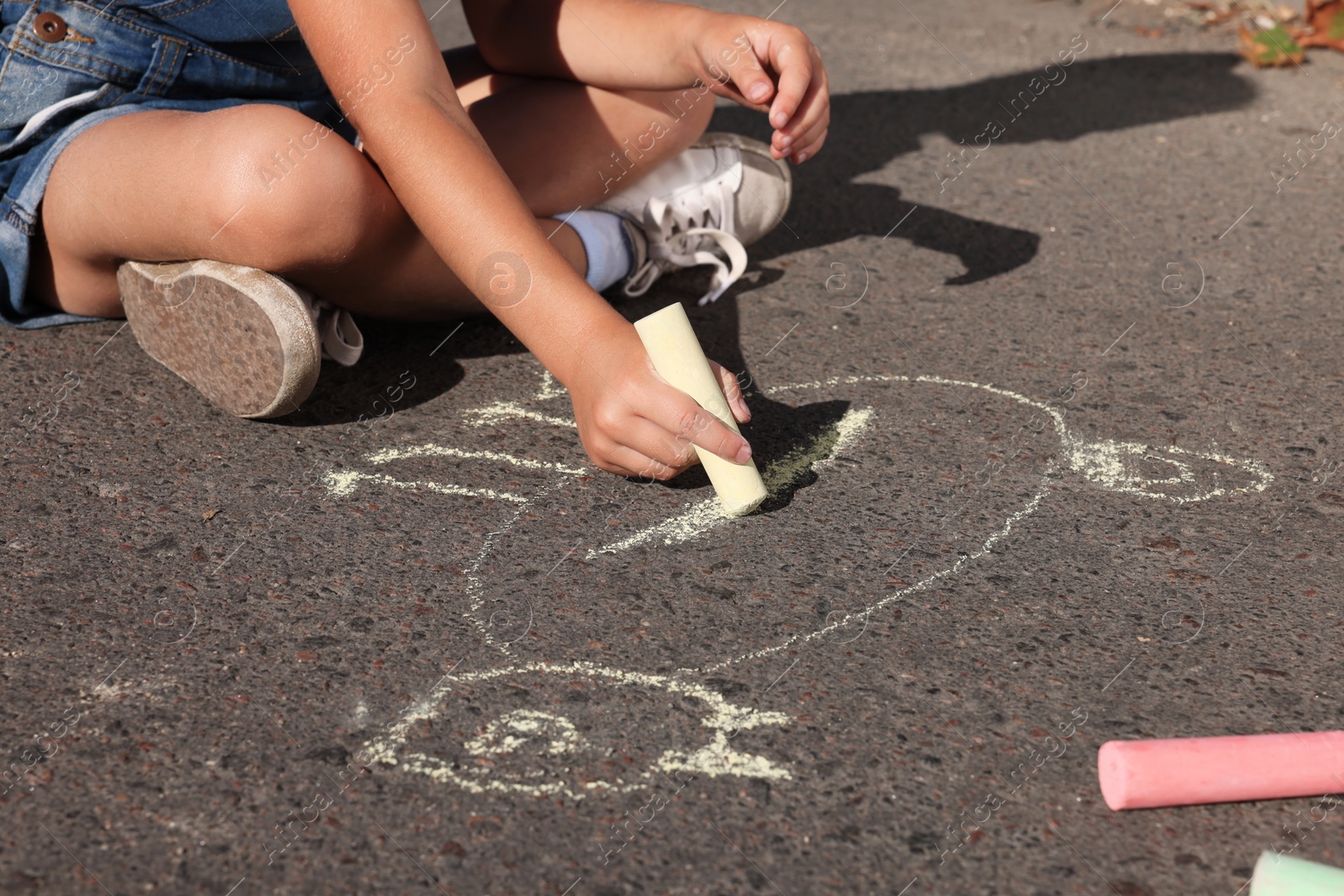 Little child drawing cat with colorful chalk on asphalt, closeup Photo of Little child drawing cat with colorful chalk on asphalt, closeup