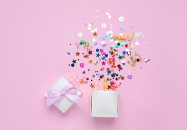 Shiny colorful confetti bursting out of box on pink background, top view Photo of Shiny colorful confetti bursting out of box on pink background, top view