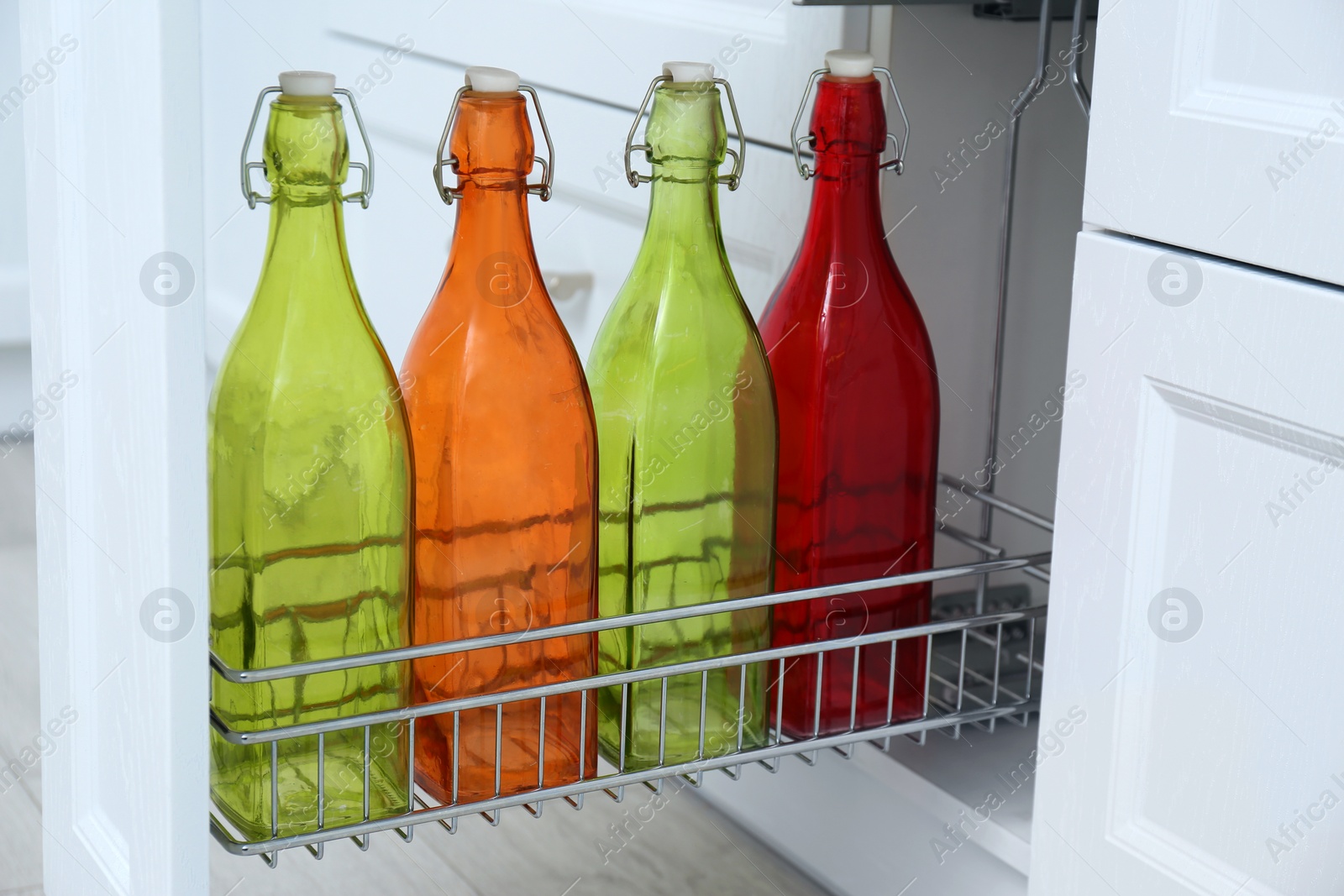 Shelf with different bottles indoors. Order in kitchen Photo of Shelf with different bottles indoors. Order in kitchen