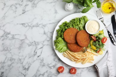 Delicious fried breaded cutlets with garnish served on white marble table, flat lay. Space for text Photo of Delicious fried breaded cutlets with garnish served on white marble table, flat lay. Space for text