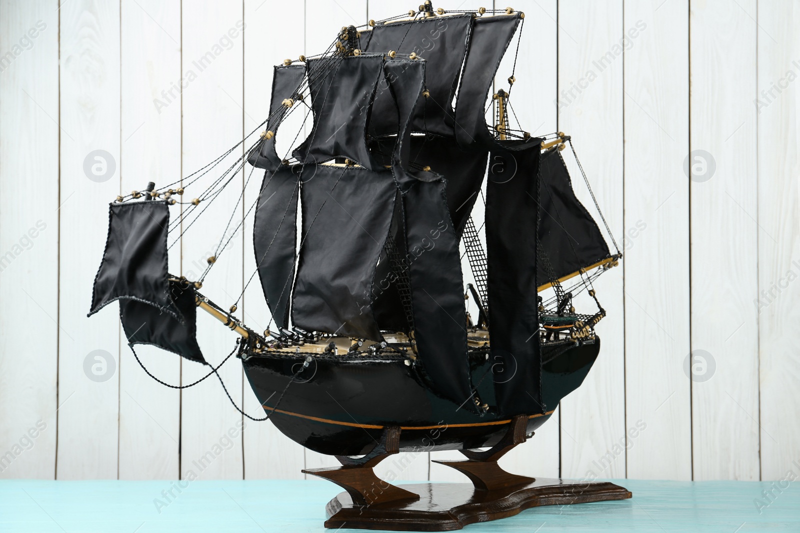 Beautiful ship model on light blue wooden table Photo of Beautiful ship model on light blue wooden table