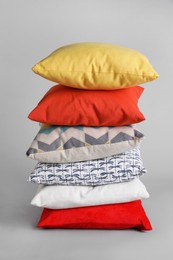 Stack of stylish soft pillows on grey background Photo of Stack of stylish soft pillows on grey background