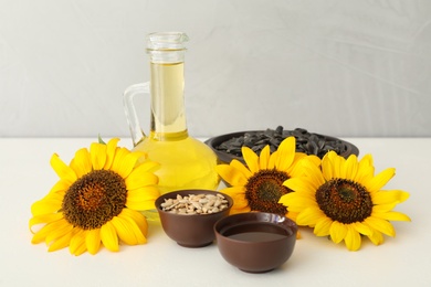 Composition with sunflower oil on white table Photo of Composition with sunflower oil on white table