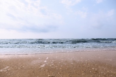 Sandy beach washed by sea on sunny day Photo of Sandy beach washed by sea on sunny day