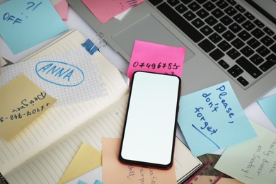 Laptop, smartphone, notes and office stationery in mess on desk, space for text. Overwhelmed with work Photo of Laptop, smartphone, notes and office stationery in mess on desk, space for text. Overwhelmed with work