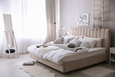 Cozy bedroom interior with beautiful picture and large mirror Photo of Cozy bedroom interior with beautiful picture and large mirror