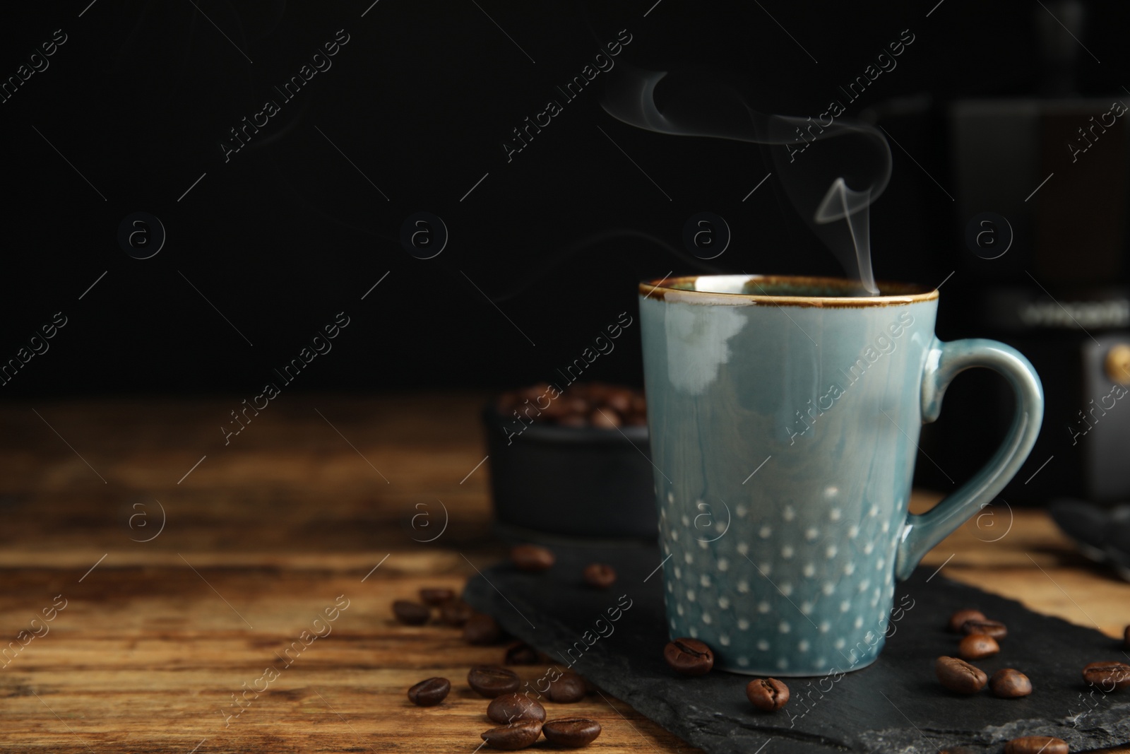 Cup of tasty coffee and beans on wooden table, space for text Photo of Cup of tasty coffee and beans on wooden table, space for text