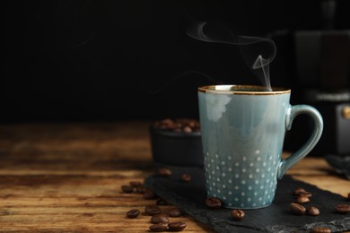 Cup of tasty coffee and beans on wooden table, space for text Photo of Cup of tasty coffee and beans on wooden table, space for text
