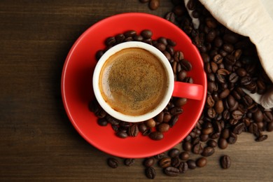 Cup of tasty coffee and beans on wooden table, flat lay Photo of Cup of tasty coffee and beans on wooden table, flat lay