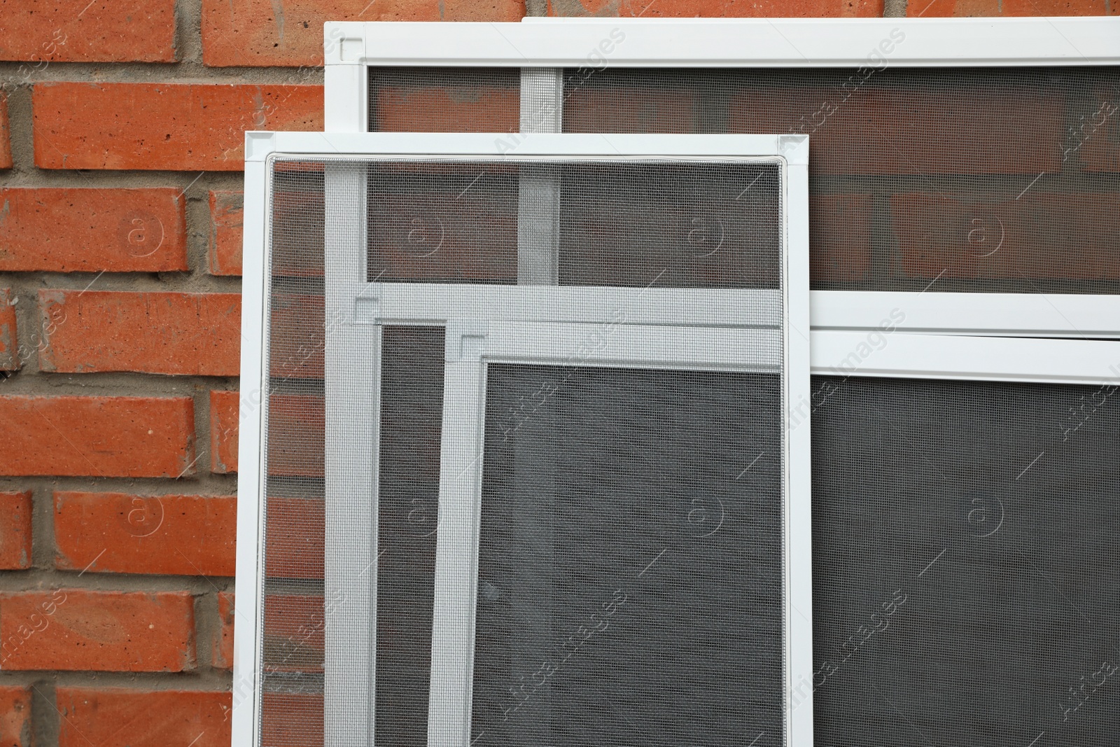 Set of window screens near brick wall Photo of Set of window screens near brick wall