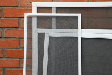 Set of window screens near brick wall Photo of Set of window screens near brick wall