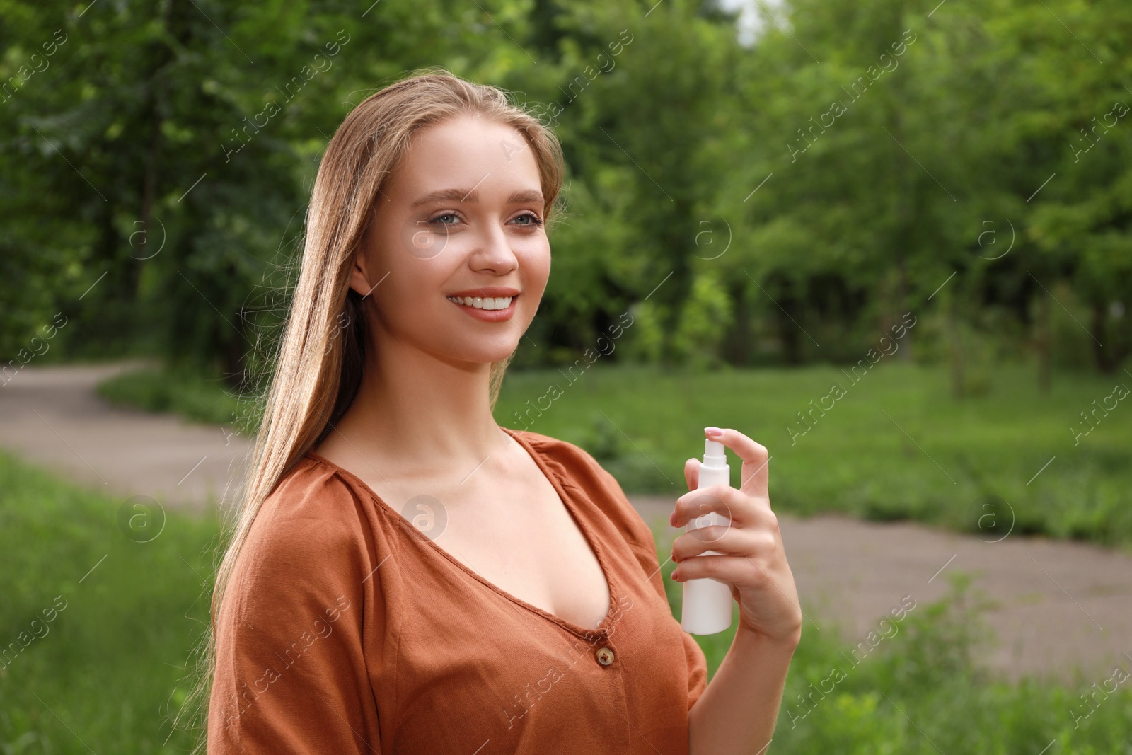 Woman using insect repellent in park. Tick bites prevention Photo of Woman using insect repellent in park. Tick bites prevention