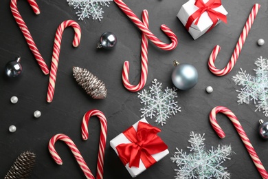 Flat lay composition with candy canes and Christmas decor on black table Photo of Flat lay composition with candy canes and Christmas decor on black table