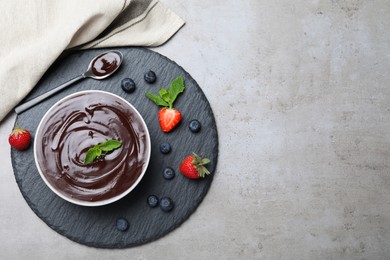Delicious chocolate cream with berries and mint on grey table, top view. Space for text Photo of Delicious chocolate cream with berries and mint on grey table, top view. Space for text
