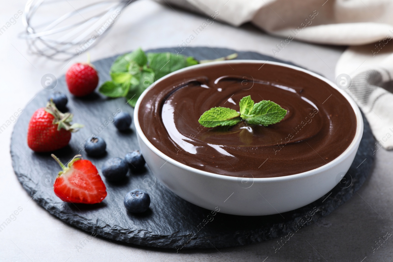 Photo of Delicious chocolate cream with berries and mint on table