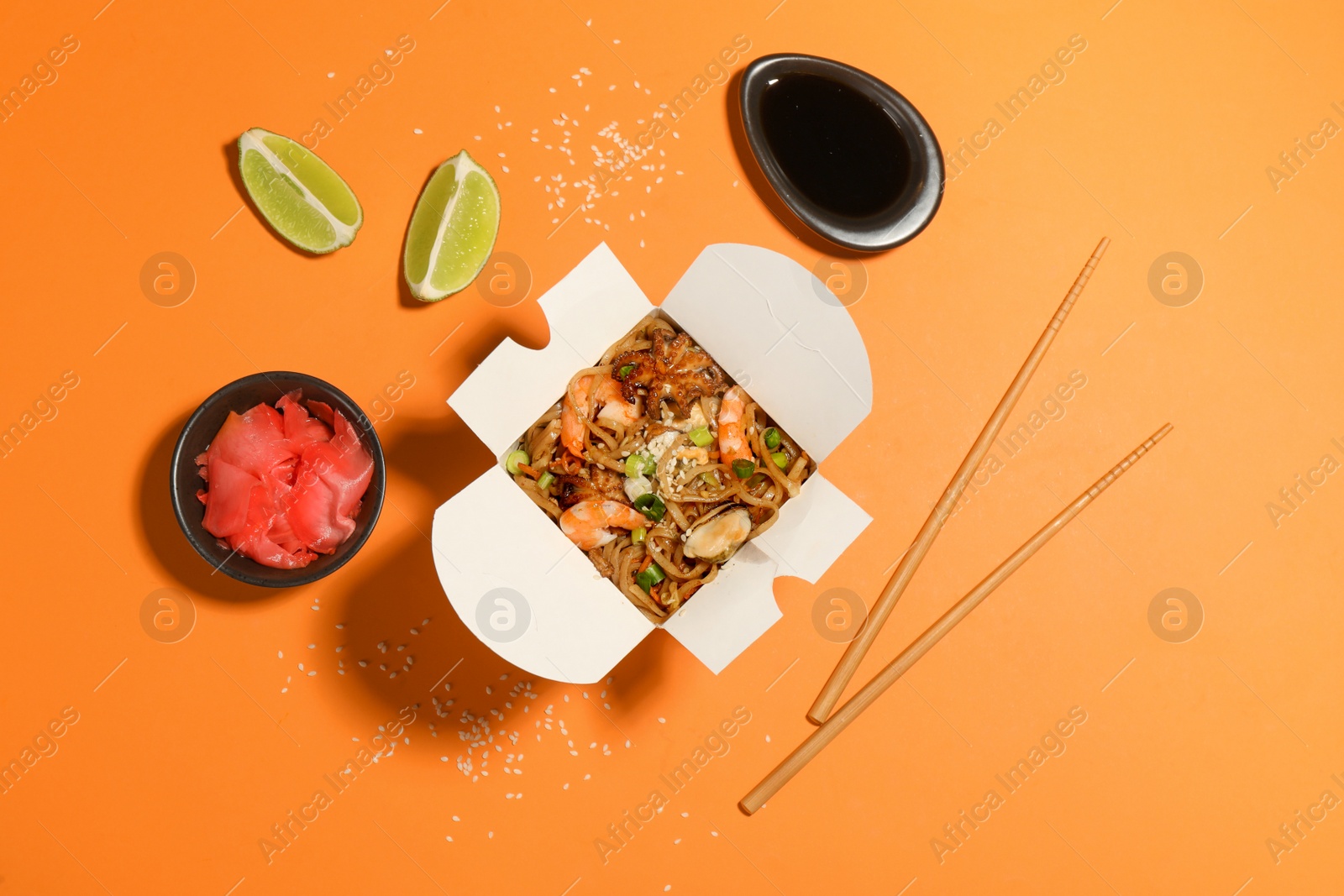 Noodle wok served on orange background, flat lay Photo of Noodle wok served on orange background, flat lay