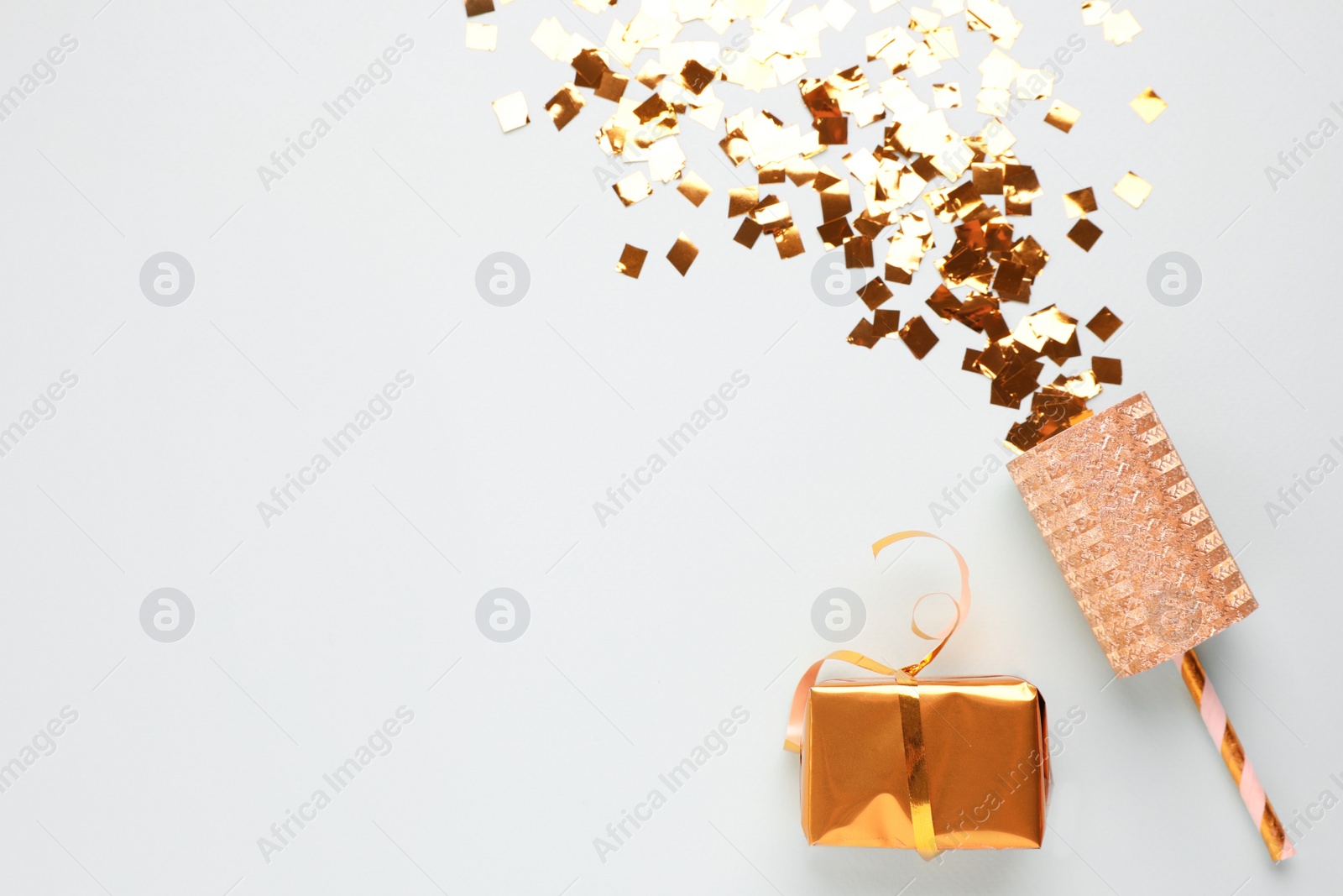 Flat lay composition with golden confetti and box on light background, space for text Photo of Flat lay composition with golden confetti and box on light background, space for text