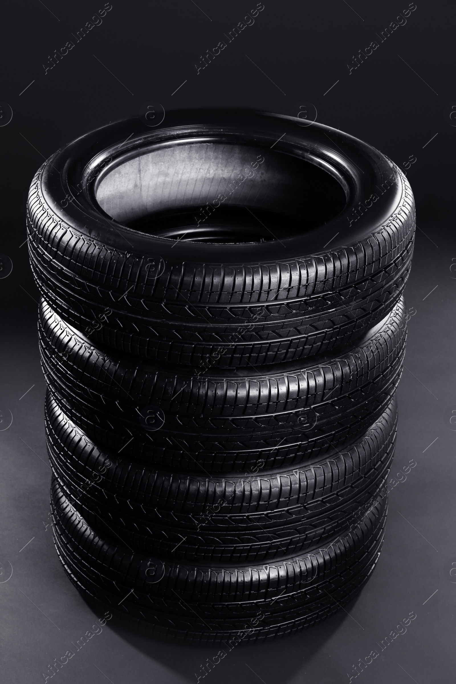 Stack of car tires on black background Photo of Stack of car tires on black background