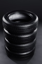 Stack of car tires on black background Photo of Stack of car tires on black background
