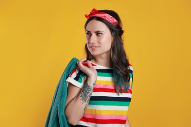 Beautiful young woman with nose piercing on yellow background Photo of Beautiful young woman with nose piercing on yellow background