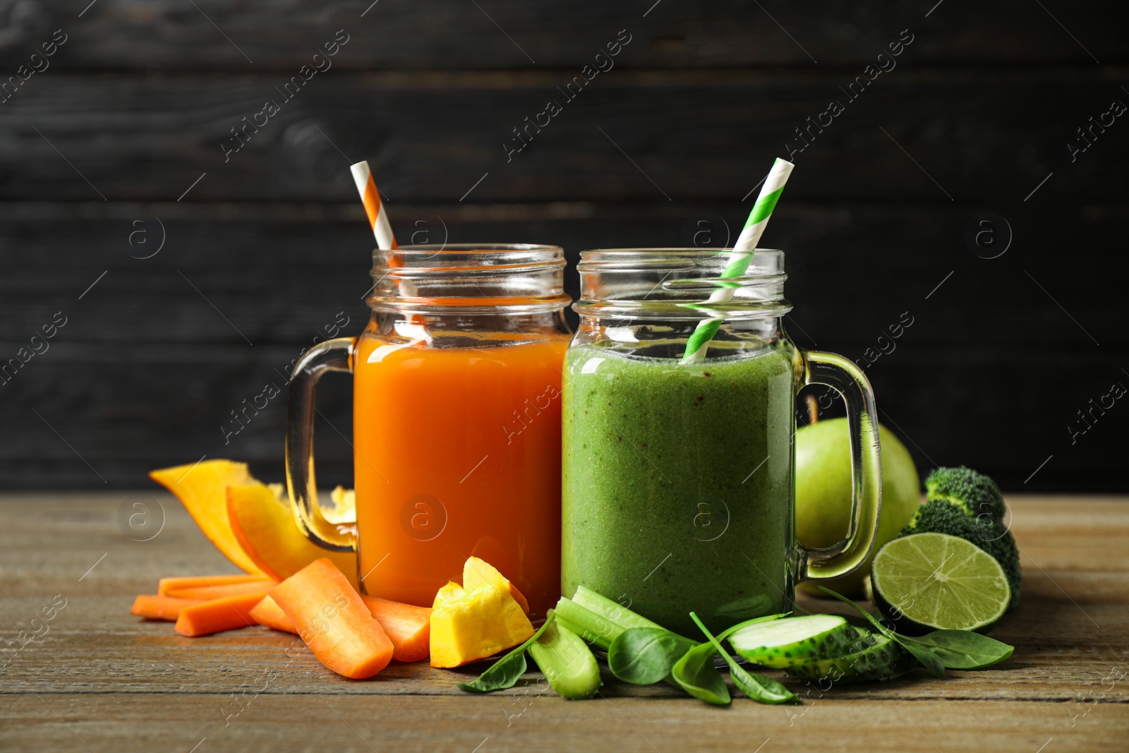 Delicious vegetable juices and fresh ingredients on wooden table Photo of Delicious vegetable juices and fresh ingredients on wooden table