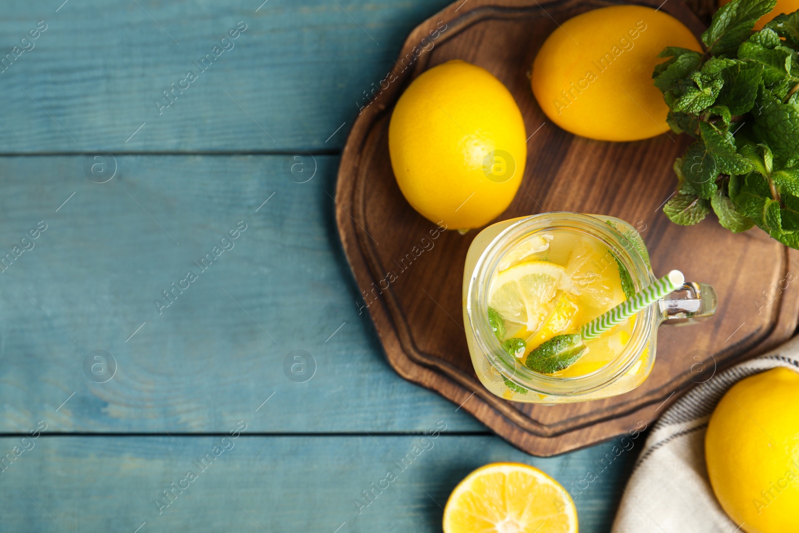 Cool freshly made lemonade and fruits on light blue wooden table, flat lay. Space for text Photo of Cool freshly made lemonade and fruits on light blue wooden table, flat lay. Space for text