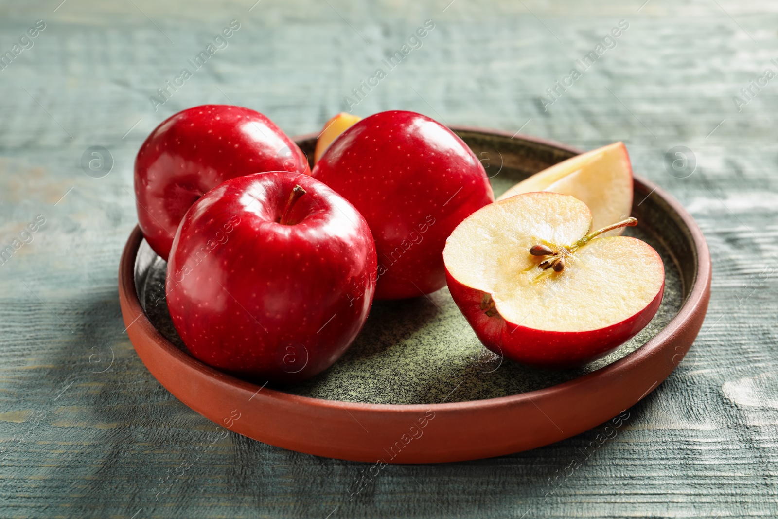 Plate with fresh ripe red apples on wooden background Photo of Plate with fresh ripe red apples on wooden background