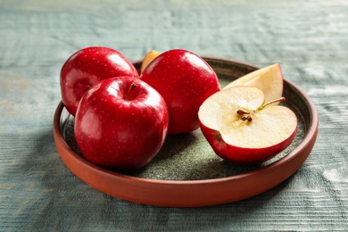 Plate with fresh ripe red apples on wooden background Photo of Plate with fresh ripe red apples on wooden background
