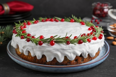 Traditional Christmas cake decorated with rosemary and cranberries on dark grey table, closeup Photo of Traditional Christmas cake decorated with rosemary and cranberries on dark grey table, closeup