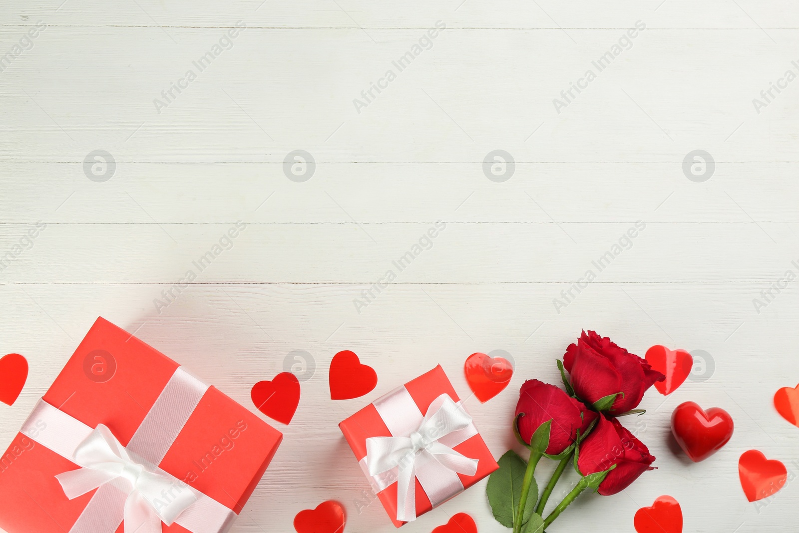 Gift boxes, roses and hearts on white wooden background, flat lay with space for text. Valentine's Day celebration Photo of Gift boxes, roses and hearts on white wooden background, flat lay with space for text. Valentine's Day celebration