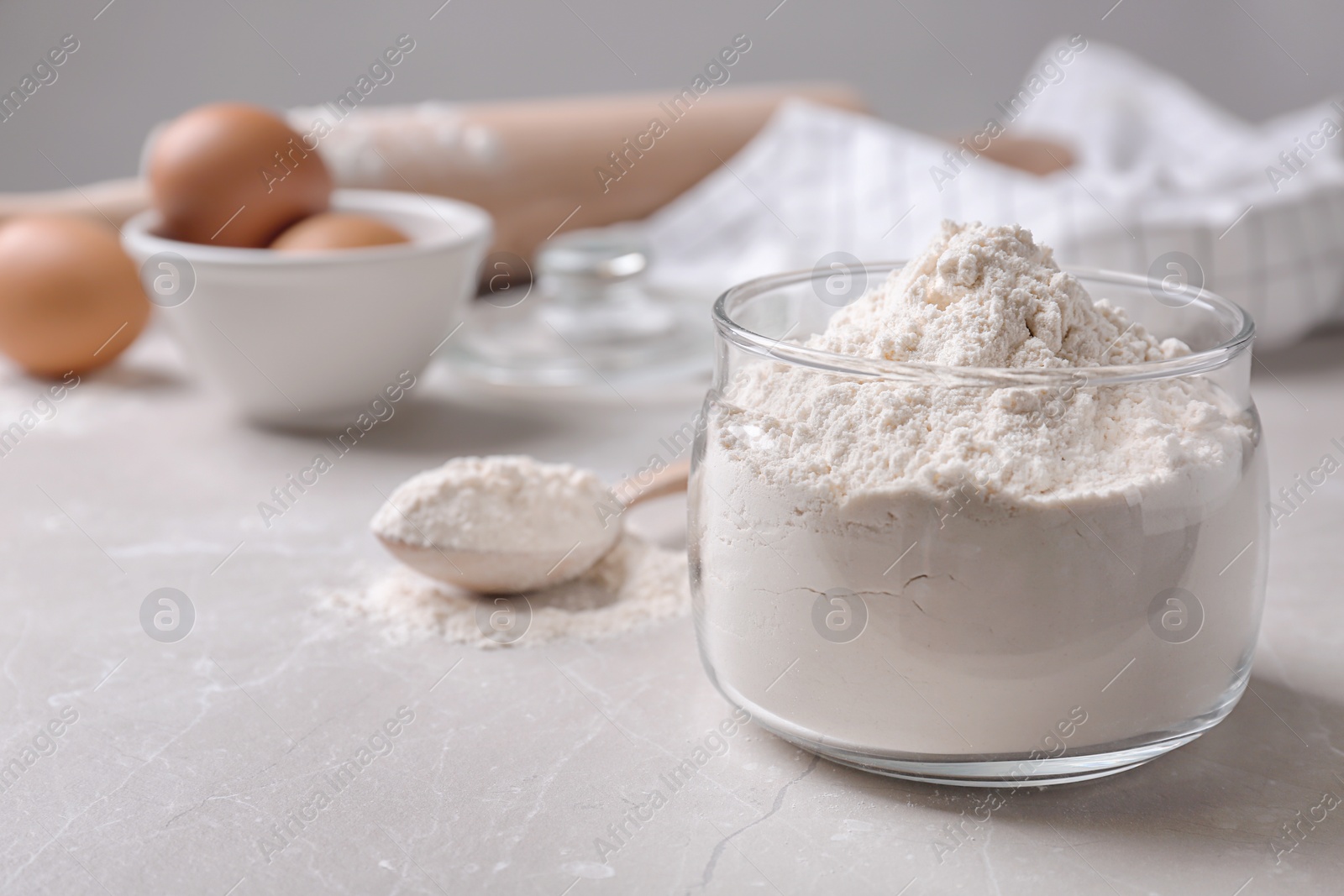 Glass bowl with flour on table Photo of Glass bowl with flour on table