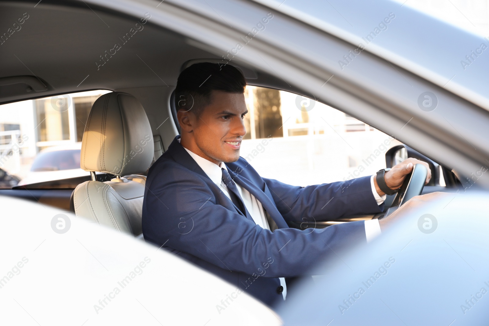 Handsome man driving his modern car, view from outside Photo of Handsome man driving his modern car, view from outside